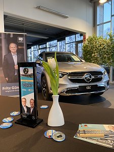 Mercedes-Benz GLC im Autohaus Peter. Auf dem Tisch davor eine Vase mit Tulpe, Flyer und CDU-Material. Im Hintergrund ein Aufsteller mit Fritz G&uuml;ntzler.