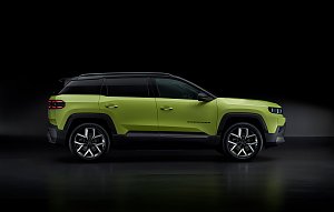 Seitenansicht des neongrünen Jeep Compass mit schwarzem Dach, großem Radstand und klarer Linienführung vor dunklem Hintergrund.