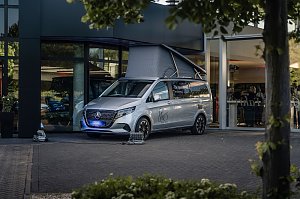 Silberner Mercedes-Van mit She�s Mercedes-Logo, vor einem Autohaus geparkt, mit ge&ouml;ffnetem Aufstelldach wie bei einem Camper.
