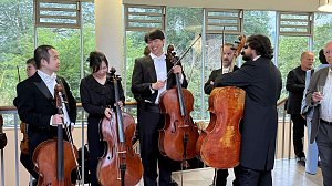 Mitglieder des Loh-Orchesters mit Celli im Gespr&auml;ch und lachend w&auml;hrend einer Pause beim Konzertabend im Achteckhaus Sondershausen.