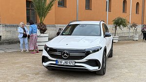 Wei&szlig;er Mercedes EQB parkt vor dem historischen Achteckhaus Sondershausen, w&auml;hrend sich G&auml;ste des Konzertabends unterhalten.