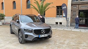 Grauer Mercedes GLB mit Autohaus-Peter-Logo vor dem historischen Achteckhaus Sondershausen, zwei G&auml;ste unterhalten sich am Fahrzeug.