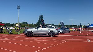 Einfahrt der Sportstars beim Leichtathletik-Meeting Anhalt 2025: Ein silberner Mercedes-Benz SUV des Autohauses Peter fährt über die rote Laufbahn, ein Sportler winkt aus dem geöffneten Schiebedach. Dahinter stehen weitere Fahrzeuge und Eventfahnen.