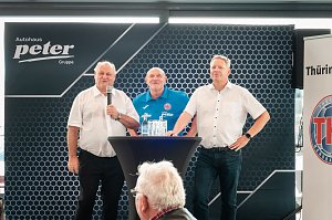 Helmut Peter (links), Herbert Müller (Mitte) und Robert Böhm (rechts) beim THC-Medientag im Autohaus Peter in Erfurt � vor einem Banner mit Autohaus-Logo, an einem Stehtisch mit Getränken.
