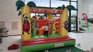 Kinder spielen auf einer bunten Hüpfburg mit Tier- und Insektenmotiven im Autohaus Autowelt Peter. Die Hüpfburg ist Teil des Familienprogramms zur Feier von 130 Jahren �koda.