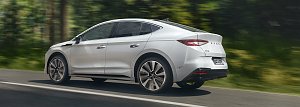 Produktbild: Skoda Enyaq Coup&eacute; in wei&szlig; f&auml;hrt schnell auf einer Stra&szlig;e im Wald