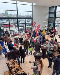 Volles Autohaus bei einem Event mit vielen Ständen.