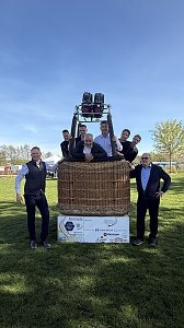 Mehrere Männer posieren für ein Foto in und um einen Ballonkorb