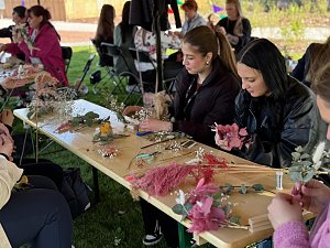 Einige Frauen basteln Trockenblumenkränze.