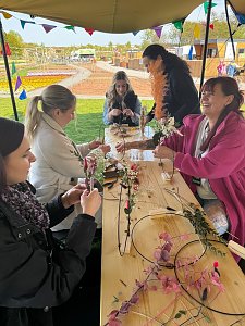 Einige Frauen basteln Trockblumenkränze.