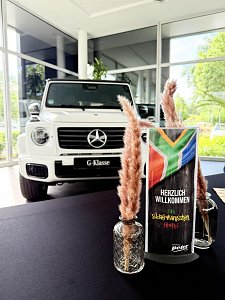 Tischdeko zum südafrikanischen Abend, im Hintergrund eine weiße Mercedes G-Klasse.