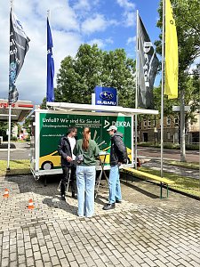 Dekra-Stand mit mehreren Personen davor.


