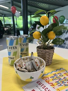 Sommerliche Tischdeko mit Zitronen, Snacks und bunten Getränkedosen
