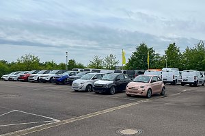 Der große asphaltierte Außenparkplatz des Autohauses Peter in Halle Neustadt/ Göttinger Bogen mit zahlreichen aufgereihten Fahrzeugen. Darunter zum Beispiel drei Fiats im Vordergrund.