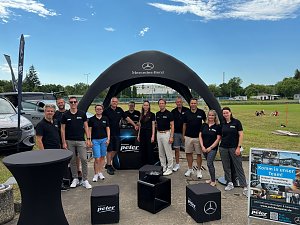 Ein Gruppenfoto des Teams vom Autohaus Peter in schwarzer Teambekleidung an unserem Stand im Paul-Greifzu-Stadion in Dessau-Ro&szlig;lau. Alle l&auml;cheln in die Kamera.