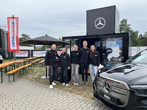 Man sieht das Team vom Autohaus Peter vor dem Promotion-Stand, alle lächeln in die Kamera.